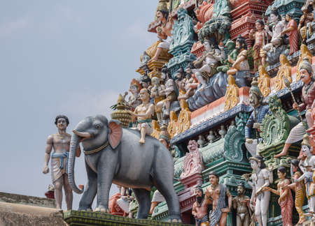 Chettinad, India - October 17, 2013:Detail of the Shiva temple gopuram at Kottaiyur shows Lord Shiva as supreme teacher and elephant walking away. Plenty of colorful statues.のeditorial素材