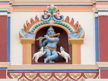 Chettinad, India - October 17, 2013: Chidambara Palace in Kadiapatti. Blue Krishna playing flute and dancing goats statue on front facade. Set in framed niche.のeditorial素材
