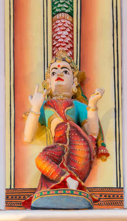 Chettinad, India - October 17, 2013: Chidambara Palace in Kadiapatti. Statue of dancing woman with orange skirt and green bustier in dance hall. Multi colored warm background.のeditorial素材