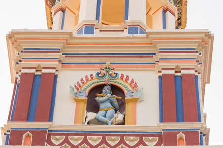 Chettinad, India - October 17, 2013: Chidambara Palace in Kadiapatti. Krishna statue on top of facade. He sits on bull and plays the flute. Niche and towers.のeditorial素材