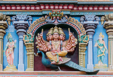 Madurai, India - October 19, 2013: Closeup of Lord Murugan. He sits on his mount the peacock and has multiple arms. Facade of Nagara Mandapam.の写真素材