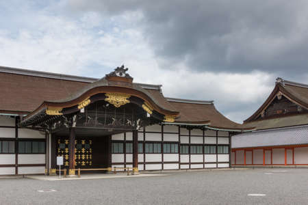 Kyoto, Japan - September 14, 2016: Highly decorated wooden entrance fronts the Shinmikurumayose hall at the Imperial Palace. Heavy skies.のeditorial素材