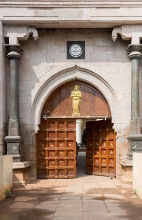 Madurai, India - October 21, 2013: The relatively small main entrance to the Nayak Palace features a  double wooden door with a golden statue on top.の写真素材