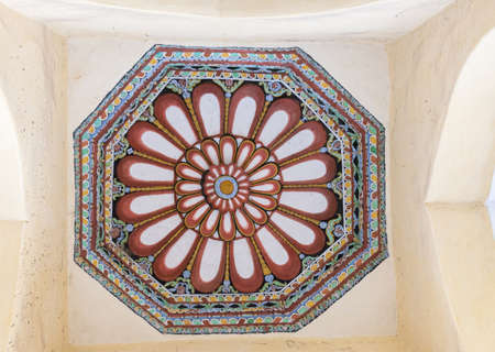 Madurai, India - October 21, 2013: Shot on the abundant decoration of one octagon ceiling at Nayak Palace. Cream with wine-colored lotus images and green, blue, yellow backgrounds.のeditorial素材
