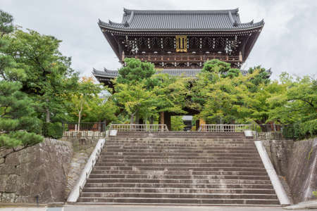 Kyoto, Japan - September 15, 2016: Monumental gate of Kurodani Buddhist Temple. Two-level gate sits on top of stairway. Green trees partially hide bottom half.のeditorial素材