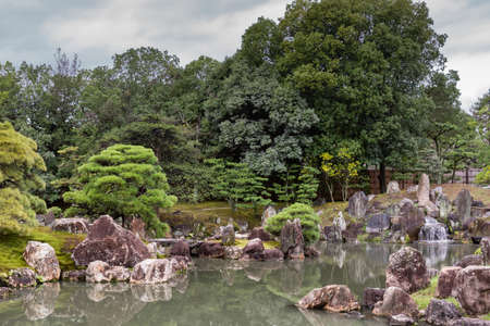 Kyoto, Japan - September 19, 2016: View on part of the garden of Ninomaru Palace at Nijo Castle. Pond, rocks, trees.のeditorial素材