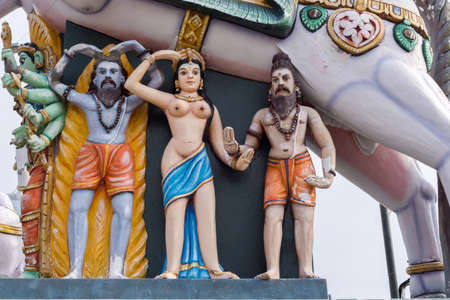 Madurai, India - October 21, 2013: Under the belly of a horse stand a half-naked, young woman and two bearded men.  All colorful statues at the shrine of Karuppana Sami near Nagamalai village.のeditorial素材