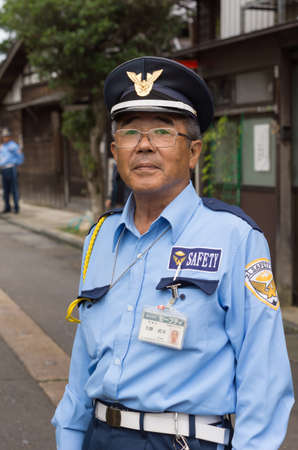 Kanazawa, Japan - September 22, 2016: Public officer is a security warden who directs traffic and parking in downtown Kanazawa. He is not a police officer but he keeps an eye on safety for all citizens in the neighborhood.のeditorial素材