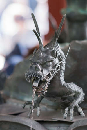 Tokyo, Japan - September 26, 2016: Closeup of metal dragon delivering water at the Chomizuya purification fountain. Senso-ji Buddhist Temple.のeditorial素材