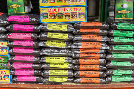 Nilgiri Hills, India - October 25, 2013: closeup of stack of different Nilgiri Hills Teas on the counter of a stall along the road. Bright colored labels tell name of teas. Plastic bags filled with tea kernels.のeditorial素材
