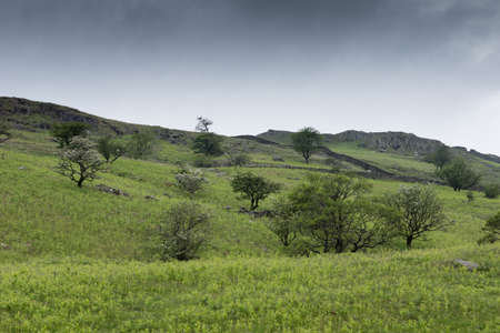 Lake District, England - May 30, 2012: Wide landscape shot under dark stormy cloudy skies shows...