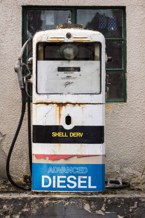 Dornoch, Scotland - June 3, 2012: Closeup of an antique mainly white gas pump. labeled Shell and Diesel. It stands in the street near a workshop and is still used to fuel trucks and tractors.のeditorial素材
