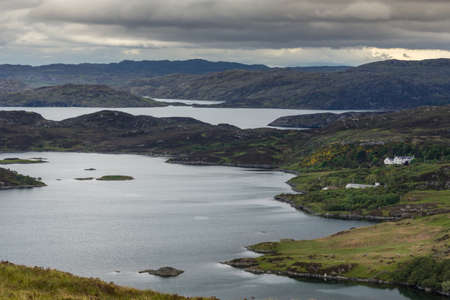 Under blue-gray cloudy sky aerial view on Loch Ardhair with intrusion of the ocean in the wild...