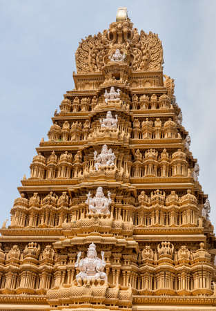 Nanjangud, India - October 26, 2013: Top six levels of main Gopuram of Sri Srikanteshware temple in Ganjangud, Karnataka State. North side. Golden decoration, white statues.のeditorial素材