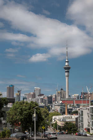 Auckland, New Zealand - March 1, 2017: From the higher lying College Hill, the Sky Tower can be seen clearly towering over the rest of the skyline with famous business names. White clouds in blue sky.のeditorial素材