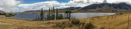 Middle Earth, New Zealand - March 14, 2017: Panorama shot of Lake Clearwater with dry wasteland in front and the mountains in the back. All under blue cloudy sky.のeditorial素材