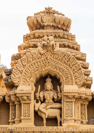 Nanjangud, India - October 26, 2013: Niche in beige elaborately decorated sandstone at Srikanteshwara Temple showing statue of Lord Shiva sitting on Nandi the bull.のeditorial素材