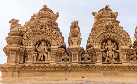 Nanjangud, India - October 26, 2013: Double Niche in beige elaborately decorated sandstone at Srikanteshwara Temple showing statue of Lord Shiva and of Lord Vishnu sitting on Garuda.のeditorial素材