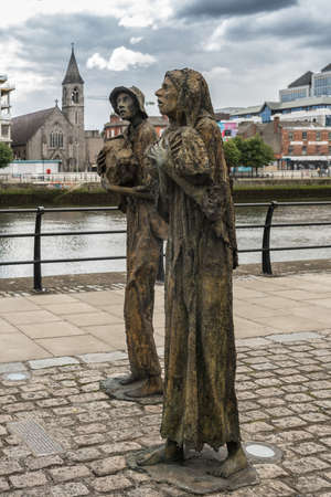 Dublin, Ireland - August 7, 2017: Great Irish Famine bronze statue set on Custom House Quay along Liffey River in Docklands.. Two figures, male and female, out of six plus dog total.のeditorial素材