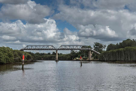 Camellia, Australia - March 24, 2017: Pipeline bridge over Parramatta River west of Sydney under cloudscape with green shores on both sides of waterway,のeditorial素材