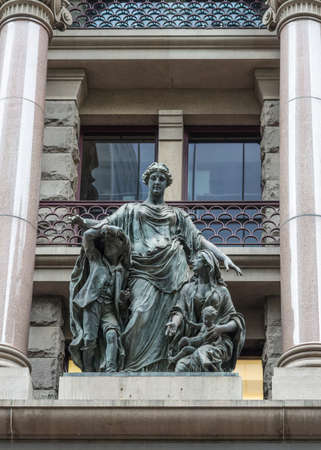 Sydney, Australia - March 25, 2017: Charity themed bronze statue of young strong woman consoling mother with teenaged boy and baby against facade of historic building.のeditorial素材