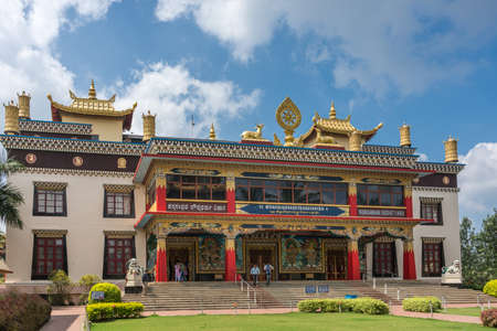 Coorg, India - October 29, 2013: Front facade and entrance to Padmasambhava Vihara at Namdroling Buddhist Monastery under blue sky and white clouds. People on stairs.のeditorial素材