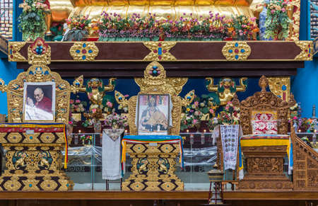 Coorg, India - October 29, 2013: Inside Padmasambhava Vihara of Namdroling Buddhist Monastery. Two golden and one wooden throne with photos of gurus.のeditorial素材