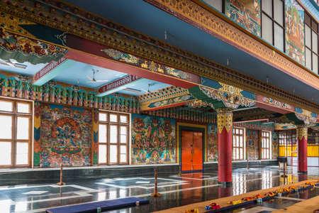 Coorg, India - October 29, 2013: Inside Padmasambhava Vihara of Namdroling Buddhist Monastery. Left side with wall paintings, windows, plillars and extensive golden decorations.のeditorial素材