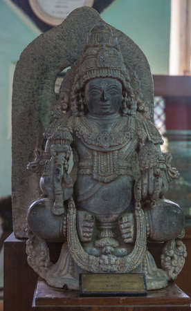 Madikeri, India - October 31, 2013: Ancient Kubera, Lord of Wealth in Hinduism, gray stone statue...