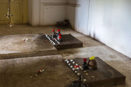 Madikeri, India - October 31, 2013: Inside dark Royal mausoleum are the flat tombs of Maharaja...