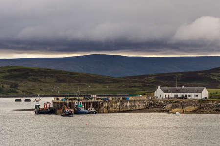 Aultbea, Scotland - June 8, 2012: Calm waters of Loch Ewe with the pier and harbor of Aultbea under...