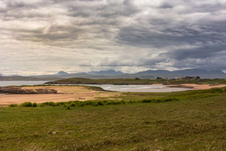 Inverasdale, Scotland - June 9, 2012: Exception brown and gray cloudscape over sandy beach...