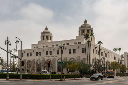 Los Angeles, CA, USA - April 5, 2018: Large two-tower beige historic United States Post Office Terminal building with green trees and cars downtown. Thick white cloudscape with emerging blues.のeditorial素材
