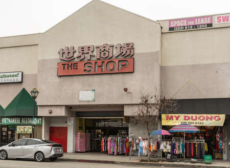 Los Angeles, CA, USA - April 5, 2018: Shopping mall along Broadway in Chinatown. Beige facade, colorful display of clothing, advertisements and street scene.のeditorial素材