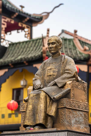 Los Angeles, CA, USA - April 5, 2018: Godlen Sun Yat-Sen statue in Central Chinatown. Closeup of his entire sitting body. Faded roof structures in back.のeditorial素材