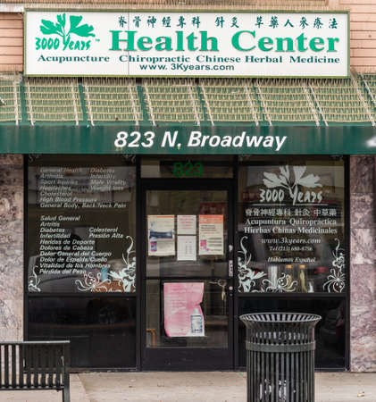 Los Angeles, CA, USA - April 5, 2018: Green building in Chinatown is Health Center selling alternative medicine such as herbs based, acupunture, and Chiropractic. Windows with texts. Street scene.のeditorial素材