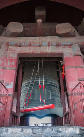 Beijing, China - April 26, 2010: Closeup of giant gray metal bell hanging from massive red support bridge in historic Bell Tower.のeditorial素材