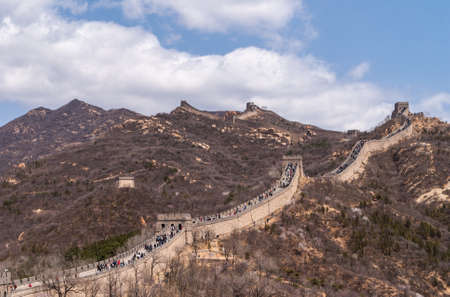 Beijing, China - April 28, 2010: Great Wall of China at Badaling. wide shot of the wall meandering over mountains with lots op people walking on top. Blue sky with white clouds.のeditorial素材