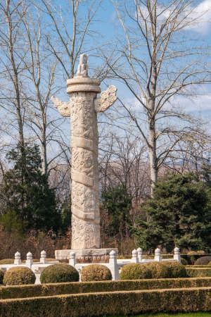 Beijing, China - April 28, 2010: Ming Dynasty Tombs domain, or Ming Changling. One of many Imperial, chiseled, white pillars in garden with spring vegetation under blue sky.のeditorial素材