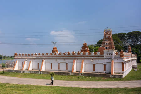 Manuganahalli, Karnataka, India - November 1, 2013: Relatively new Arkeshwara temple at Kaveri River as original is submerged. White walls, brown Gopuram, one person, blue sky.のeditorial素材