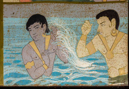 Shravanabelagola, Karnataka, India - November 1, 2013: Bhandar Basadi temple complex. Metal plate painting of one male throwing water in face of other male. Pastel colors spoiled with rust spots.のeditorial素材