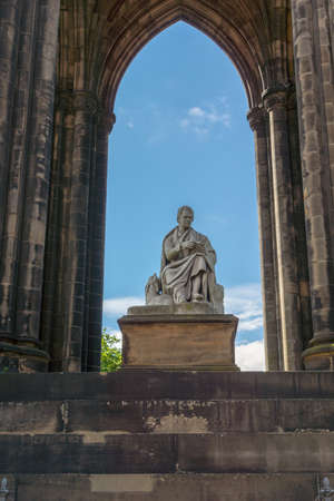 Edinburgh, Scotland, UK - June 13, 2012: Looking through Scott Monument with blue sky in back. Statue of Sir Walter Scott in center close up framed by dark stone pillars.のeditorial素材
