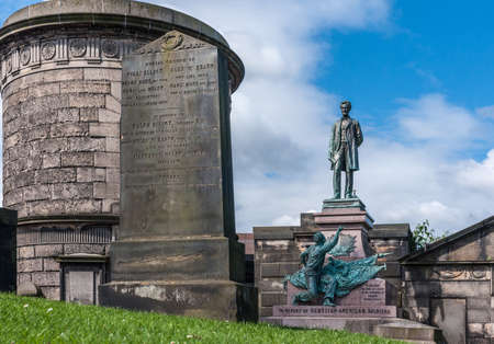 Edinburgh, Scotland, UK - June 13, 2012: Abraham Lincoln bronze statue with surrounding brown stone tombs on Old Calton Cemetery. Blue sky with white clouds.のeditorial素材