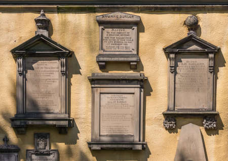 Edinburgh, Scotland, UK - June 13, 2012: Memorial plates set in yellow Flodden Wall at Greyfriars...