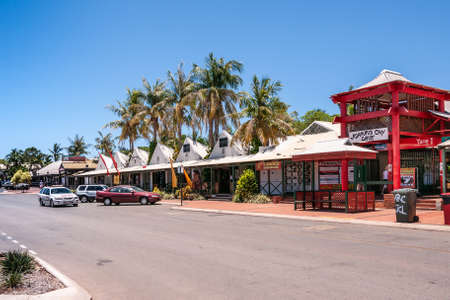 Broome, WA, Australia - November 29, 2009: Street view with cars and people in front of white and red Johnny Chi Lane shopping mall with palm trees and blue sky.のeditorial素材