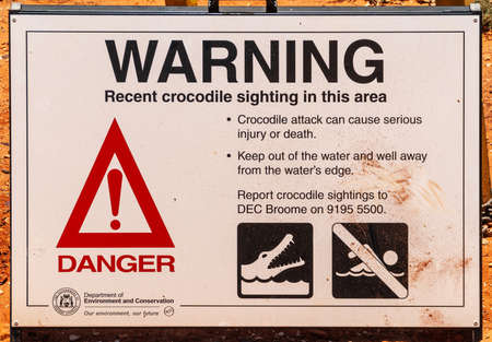 Broome, WA, Australia - November 29, 2009: Public display poster by government about the recent sighting of crocodiles in the area. Advice what not to do is spelled out.のeditorial素材