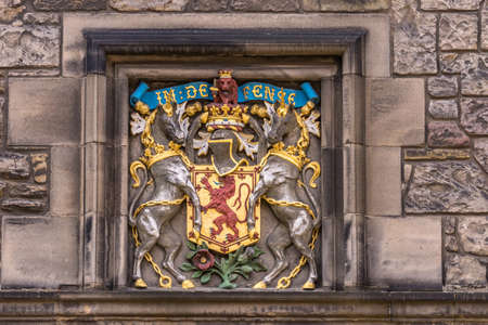 Edinburgh, Scotland, UK - June 14, 2012: Closeup of Royal Scottish Lion emblem, on shield with two unicorns and slogan In Defence, on brown stone building at Castle.のeditorial素材