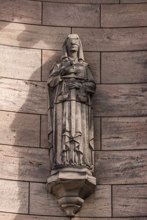 Edinburgh, Scotland, UK - June 14, 2012: Brown stone blindfolded lady justice statue with sword ad scales at Castle.のeditorial素材