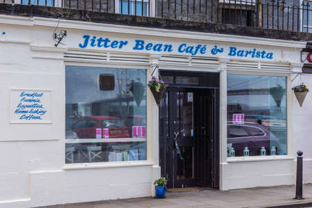 Queensferry, Scotland, UK - June 14, 2012: white painted facade of Jitter Bean CafÃ© and Barista on High Street. Cars reflected in windows.のeditorial素材
