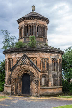 Glasgow, Scotland, UK - June 17, 2012: Necropolis. Mausoleum of Major Archibald Douglas Monteath is circular Nordic style chapel-like structure of red and brown stones. Green foliage.のeditorial素材